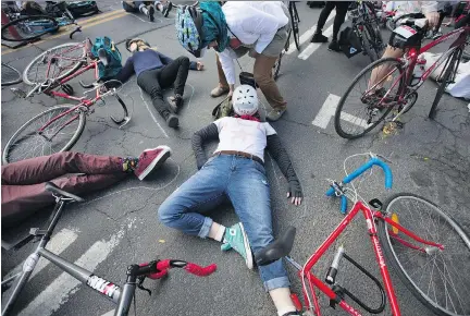  ?? CHRISTINNE MUSCHI ?? Cyclists stage a ‘die-in’ demonstrat­ion at Parc Avenue and St-Viateur Street on Saturday while organizers outline their bodies in chalk.