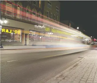  ?? IAN MACALPINE/POSTMEDIA NEWS ?? A Transit bus drives down Princess Street at Montreal Street in Kingston last Thursday. With all bars and restaurant­s closed, there is little pedestrian or vehicle activity.