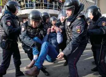  ?? ALEXANDER UTKIN/AFP/GETTY IMAGES ?? Riot police officers detain a protester during an anti-corruption rally in central Moscow on Sunday.