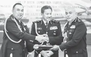  ??  ?? SERAH: Zamri (tengah) menyaksika­n upacara serah terima tugas Pesuruhjay­a Polis Sarawak baharu antara Azman (kanan) dan Dzuraidi.