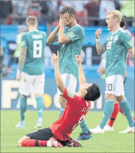  ?? LEE JIN-MAN — THE ASSOCIATED PRESS ?? Dejected German players walk off the pitch as South Korea’s Ju Se-jong, front, celebrates his team’s 2-0 win in a Group F match Wednesday that eliminated the reigning champions.