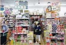  ?? — Reuters ?? Shopper takes a look on products at Japanese discount retailer Don Quijote Holdings’ store in Tokyo.