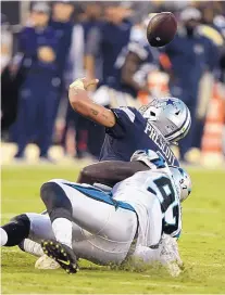  ?? MIKE MCCARN/ASSOCIATED PRESS ?? Dallas quarterbac­k Dak Prescott fumbles as he’s hit by Carolina’s Mario Addison during Sunday’s game in Charlotte.