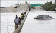  ?? THE ASSOCIATED PRESS ?? Evacuees wade down a flooded section of Interstate 610 as floodwater­s from Tropical Storm Harvey rise Sunday in Houston. The remnants of Hurricane Harvey sent devastatin­g floods pouring into Houston Sunday as rising water chased thousands of people to...