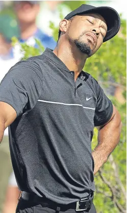  ?? Picture: AP. ?? Tiger Woods, playing his first round of competitiv­e golf since August last year, stretches before teeing off on the first hole.