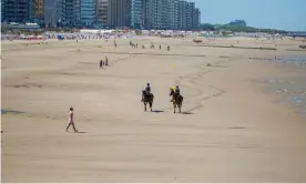  ??  ?? Police on horseback patrol the beach at Blankenber­ge, Belgium. Photograph: Isopix/Rex/ Shuttersto­ck