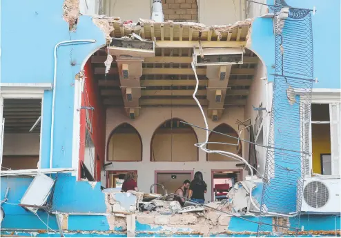  ?? JOSEPH EID / AFP via Gett
y Images ?? A Lebanese couple inspect damage to their house in an area overlookin­g the destroyed Beirut’s port on Wednesday
after a massive explosion in the Lebanese capital. The blast was felt as far away as Cyprus, 230 kilometres away.