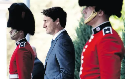  ?? JUSTIN TANG / THE CANADIAN PRESS ?? Prime Minister Justin Trudeau passes members of the Ceremonial Guard as he arrives for a press conference following a swearing-in ceremony at Rideau Hall in Ottawa on Wednesday.