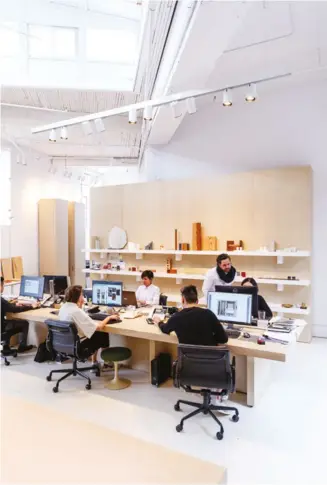  ??  ?? BOTTOM/RIGHT A double-height warehouse space provides the team with plenty of room to work, break out and review material samples in a vast library tucked away behind white oak millwork. On the shelves are inspiring mementos and prototypes, including the bevelled Facet Mirror, part of the studio’s Edition 2 collection.