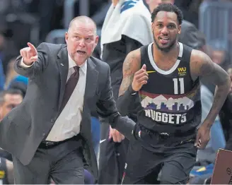  ??  ?? Nuggets coach Michael Malone signals for Monte Morris (11) to get into the game against the Minnesota Timberwolv­es during the fourth quarter Sunday at the Pepsi Center.