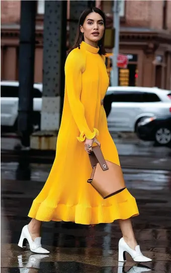  ??  ?? Bag it up: Blogger Camila Coelho pairs a Danse Lente mini Johnny bucket bag with a Tibi dress