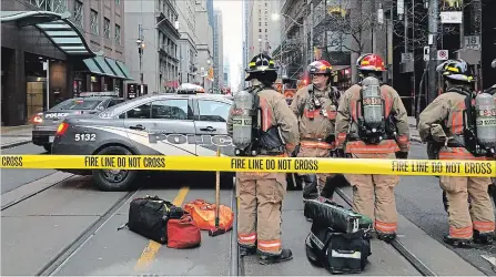  ?? GRAEME ROY THE CANADIAN PRESS ?? Firefighte­rs stand by their equipment after a bomb threat evacuated the King Street subway station in downtown Toronto, Thursday. Police in Toronto, Calgary, Ottawa and Winnipeg, as well as several RCMP detachment­s, were all investigat­ing multiple threats. Meantime, law enforcemen­t agencies in the U.S. dismissed a series of threats, which they said were meant to cause disruption and compel recipients to send money.