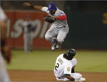  ?? NHAT V. MEYER — BAY AREA NEWS GROUP FILE ?? The Rangers’ Elvis Andrus jumps out of the way after tagging-out the A’s Khris Davis (2) at second base in the eighth inning at the Coliseum in Oakland in August of 2018.