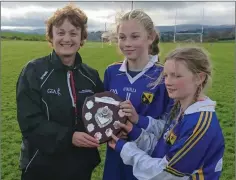  ??  ?? Cathy Forde presents the Girls First Year Football trophy to Colaiste Bhride joint captains Sadhbh Buttle and Melissa Doran.