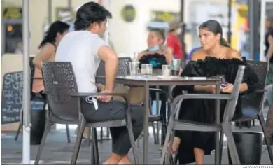  ?? ANTONIO PIZARRO ?? Dos jóvenes, sentados en un velador del centro de Sevilla el pasado lunes.