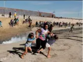  ??  ?? Migrants flee as tear gas is fired at them at the Mexico-us border