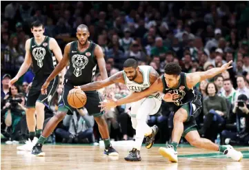  ??  ?? Kyrie Irving of the Boston Celtics (second right) and Malcolm Brogdon of the Milwaukee Bucks battle for a loose ball during the second half at TD Garden in Boston, Massachuse­tts. — AFP photo