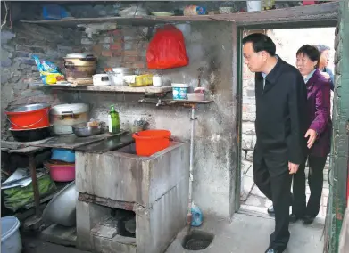  ?? LIU ZHEN / CHINA NEWS SERVICE ?? Premier Li Keqiang visits a shantytown home in Jinan, Shandong province, on Friday. Zhang Shirong, 77, has lived in the unheated house with her husband for 42 years.