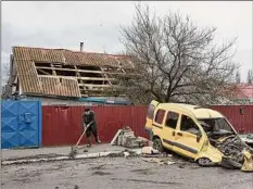  ?? Alexey Furman / Getty Images ?? A man clears the rubble in front of his house on Saturday in Borodianka, Ukraine.