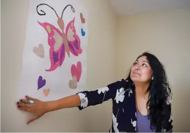  ??  ?? Lisa Arviso, med tech supervisor for the women and children’s unit at the Santa Fe Recovery Center, puts up a butterfly painting as she prepares a bedroom for a mother and her child. The center recently started the only intensive residentia­l addiction treatment program in New Mexico allowing mothers to bring in their infants and toddlers.