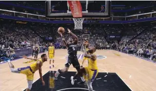  ?? ROCKY WIDNER/AFP PHOTO ?? SINYAL BANGKIT: De’Aaron Fox (tengah) dihadang LeBron James (kanan) saat hendak memasukkan bola.