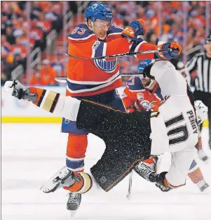  ?? CP PHOTO ?? Edmonton Oilers defenceman Matthew Benning (left) hits Anaheim Ducks right wing Corey Perry during NHL playoff action in Edmonton on Wednesday.