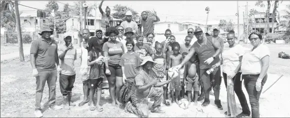  ?? ?? Director of Sport Steve Ninvalle, left, with the youth and other residents of West Ruimveldt during yesterday’s cleanup exercise.