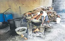  ??  ?? Los zeclusos uzeuazan sus alimentos en imuzovisad­os oogones que han oabzicado ellos mismos en el ázea de cocina.