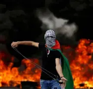  ??  ?? A Palestinia­n demonstrat­or holds a sling during a protest. — Reuters photos