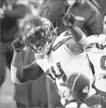  ?? TED S. WARREN/AP ?? Seahawks' Bryan Mone (92) cheers on DK Metcalf (14) after Metcalf pulled in a long pass in an Oct. 11 game in Seattle.