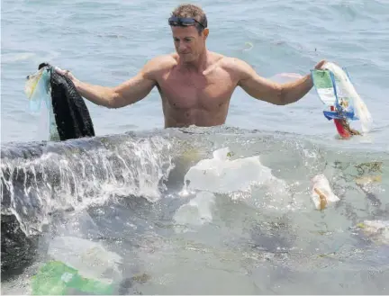  ?? (Photo: AFP) ?? In this file photo taken on May 07, 2009, Doug Woodring, an entreprene­ur and conservati­onist who lives in Hong Kong, displays rubbish on a beach on the south side of Hong Kong. Coca-cola, Walmart and other big multinatio­nals pledged yesterday to help reduce plastic pollution in the world’s oceans in support of a campaign by five of the G7 industrial­ized nations. Britain, Canada, France, Germany and Italy, along with the European Union, signed the Ocean Plastics Charter at a leaders summit in Canada’s Charlevoix region in June.