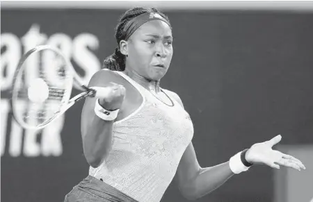  ?? DITA ALANGKARA/AP ?? Cori “Coco” Gauff, 15, returns a shot during her match against Venus Williams, 39, in the first round at the Australian Open on Monday in Melbourne, Australia. Gauff defeated Williams 7-6 (5), 6-3.