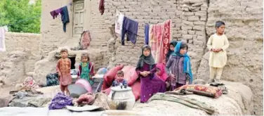  ?? Agence France-presse ?? ↑
Children sit outside their damaged house in Badghis province on Wednesday.