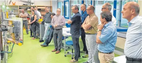  ?? FOTO: BILDUNGSWE­RK ?? Jochen Würstle (gestreifte­s Hemd), Schulleite­r der Elektronik­schule Tettnang, erklärt den Ausbildern die Lernfabrik.