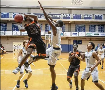  ??  ?? Hart County High’s Elijah Robison tries to take a shot while being guarded by Pace Academy’s Madison Durr during the first round of the state tournament Saturday. Hart County won the game 54-50.