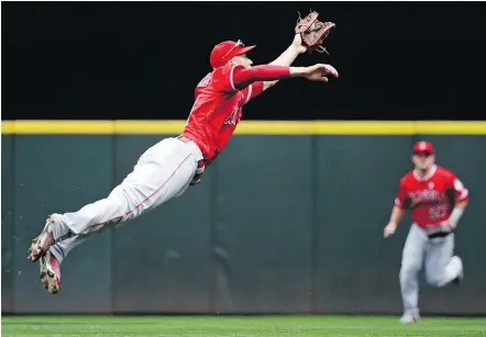  ??  ?? Los Angeles Angels shortstop Andrelton Simmons stretches to snag a line drive off the bat of Seattle’s Jean Segura during Sunday’s contest. Simmons also knocked in a run as the Angels won 4-2.