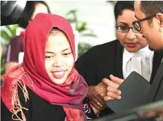  ??  ?? Siti Aisyah (centre) smiles while leaving the Shah Alam High Court (See also Page 15). — AFP photo