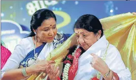  ?? AFP ?? Asha Bhosle felicitati­ng Lata Mangeshkar during Pandit Hridaynath Mangeshkar’ Awards in 2013.