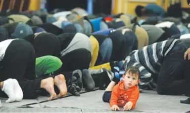  ??  ?? Men bow in prayer Friday during the funeral for 1994 Heisman Trophy winner Rashaan Salaam at the Islamic Center of Boulder. Salaam was 42 when he died Monday of an apparent suicide. Brennan Linsley, The Associated Press