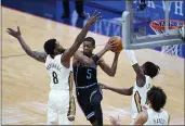  ?? GERALD HERBERT — THE ASSOCIATED PRESS ?? Sacramento Kings guard De’Aaron Fox drives to the basket between New Orleans Pelicans forward Naji Marshall (8), guard Kira Lewis Jr. (13) and center Jaxson Hayes in the first half Monday. The Pelicans won 117-110.