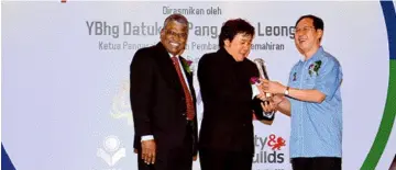  ??  ?? Dr Pang (right) receives a souvenir from MySkills Fair 2015 organising committee chairman PeterWong accompanie­d by FeMAC president P.Sailanatha­n (left) after the launching ceremony. – Bernama photo