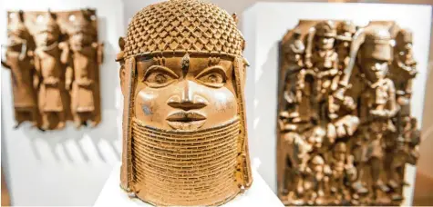  ?? Foto: Daniel Bockwoldt, dpa ?? Drei Benin‰Bronzen aus Nigeria sind im Hamburger Museum für Kunst und Gewerbe in einer Vitrine ausgestell­t.