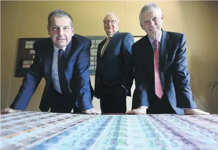  ?? JULIE OLIVER ?? Reserve Bank of New Zealand deputy governor Geoff Bascand, left, and governor Graeme Wheeler, right, flank Ronald Arends, CEO and president of the Canadian Bank Note Co., in front of sheets of their country’s currency, which is printed here in Ottawa.