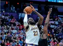  ?? GERALD HERBERT/THE ASSOCIATED PRESS ?? Los Angeles Lakers forward LeBron James shoots against New Orleans Pelicans forward Zion Williamson in the first half of Sunday’s game in New Orleans. NBA play-in games begin Tuesday.