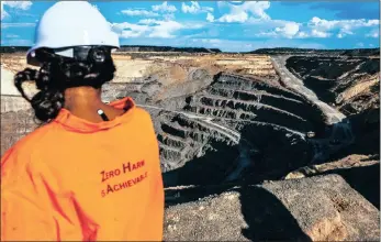  ??  ?? An employee looks across the open pit of the Voorspoed diamond mine, operated by De Beers in Kroonstad.