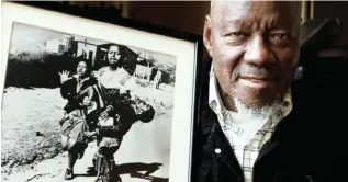  ?? Picture AP/African News Agency (ANA) ?? ICONIC: South African photograph­er Sam Nzima with his photograph of 13-year-old Hector Pieterson being carried after being shot by police during the 1976 Soweto uprising.