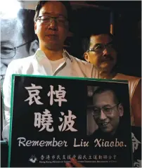  ?? (Bobby Yip/Reuters) ?? DEMOCRACY ACTIVISTS mourn the death of Chinese Nobel Peace laureate Liu Xiaobo, outside China’s Liaison Office in Hong Kong yesterday.