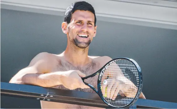  ??  ?? World No.1 Novak Djokovic chats with fans from his hotel balcony during his stint in quarantine in Adelaide. Picture: AFP