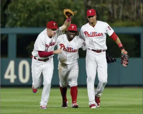  ?? DERIK HAMILTON — THE ASSOCIATED PRESS ?? From left, the Phillies’ Rhys Hoskins, Odubel Herrera and Aaron Altherr against the Arizona Diamondbac­ks on Wednesday. celebrate in the outfield after a 5-3 victory