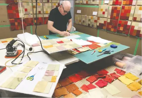  ?? CLARA KING ?? Volunteers at St. George’s Anglican Church have put in more than 900 hours sewing, embroideri­ng, silk screening and assembling an enormous tapestry for its future worship space comprised of 100 square panels in varying colours of dupioni silk, hung individual­ly on the wall.